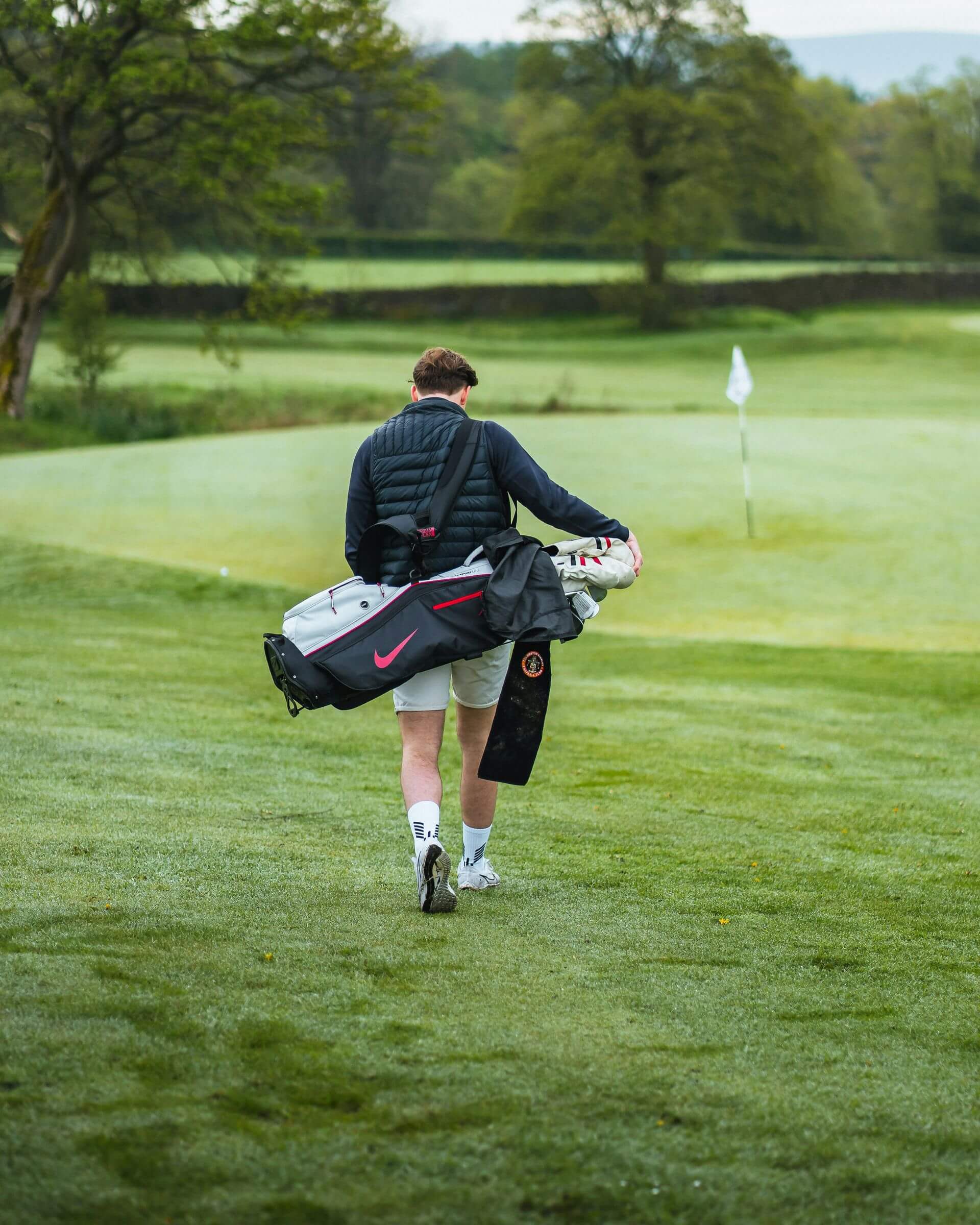 boy walking with golf bag on his back