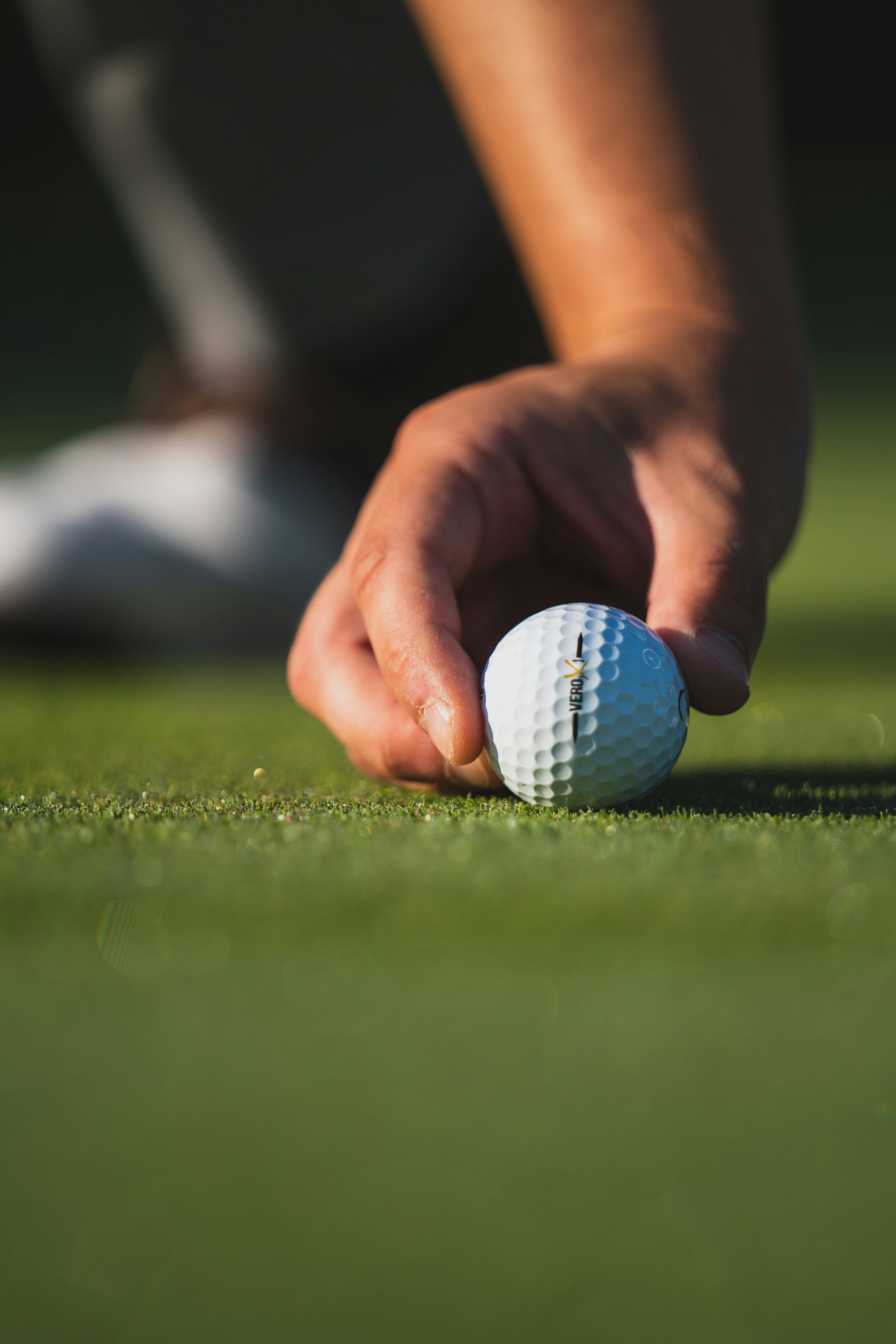 Man lining up a golf ball on the green