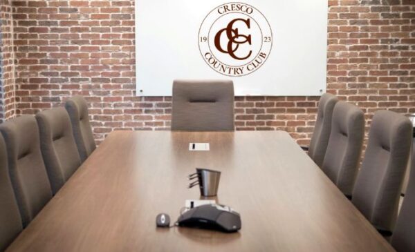 Empty board room with Cresco Country Club logo on wall